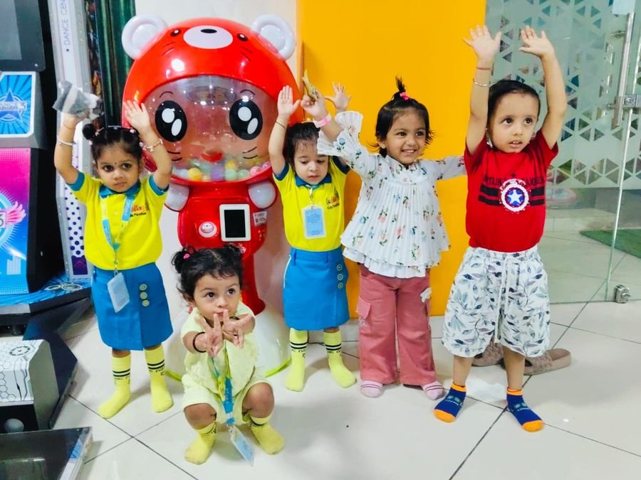 Children posing with a bear-shaped gumball machine during an outing