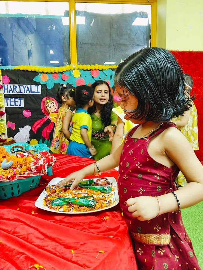 A child at the Hariyali Teej celebration table with bangles and flowers