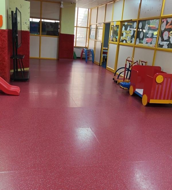 The indoor play corridor with a slide and ride-on toys