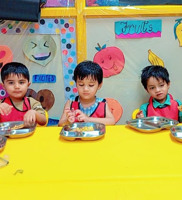 Children eating from steel plates at meal time